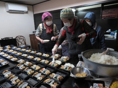 As they prepare lunch boxes, volunteer residents discuss anything from local supermarket offerings to life in the evacuation sites. As they prepare lunch boxes, volunteer residents discuss anything from local supermarket offerings to life in the evacuation sites.