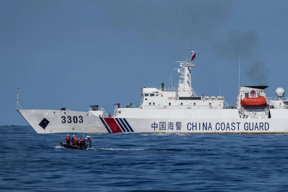A boat carrying Philippine Coast Guard personnel moves past a China Coast Guard ship during a resupply mission in the disputed South China Sea on Nov. 10, 2023. A boat carrying Philippine Coast Guard personnel moves past a China Coast Guard ship during a resupply mission in the disputed South China Sea on Nov. 10, 2023.
