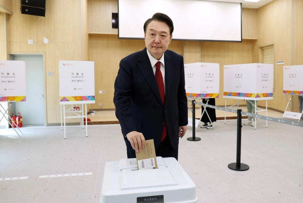 South Korean President Yoon Suk-yeol casts his ballot during early voting in parliamentary elections at a polling station in Busan, South Korea, on Friday, ahead of Election Day on Wednesday. South Korean President Yoon Suk-yeol casts his ballot during early voting in parliamentary elections at a polling station in Busan, South Korea, on Friday, ahead of Election Day on Wednesday.