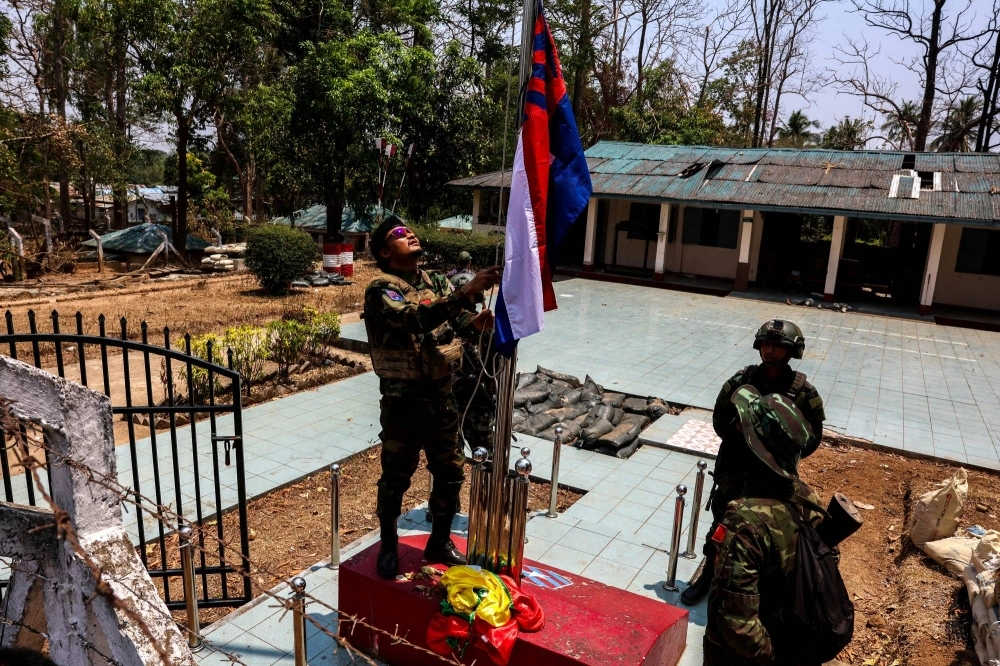 A rebel fighter of the Karen National Liberation Army (KNLA) raises Karen's national flag after burning Myanmar's national flag in Myawaddy, a Thailand-Myanmar border town, on Monday. A rebel fighter of the Karen National Liberation Army (KNLA) raises Karen's national flag after burning Myanmar's national flag in Myawaddy, a Thailand-Myanmar border town, on Monday.