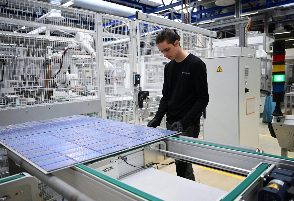 Max Lange, 19, a plant mechatronics engineering trainee from Oederan, stands next to a solar panel rolling off the assembly line as part of the last production of solar modules at the Meyer Burger Technology AG plant, due to an announced closure of the plant, in Freiberg, Germany, on March 12. Max Lange, 19, a plant mechatronics engineering trainee from Oederan, stands next to a solar panel rolling off the assembly line as part of the last production of solar modules at the Meyer Burger Technology AG plant, due to an announced closure of the plant, in Freiberg, Germany, on March 12.