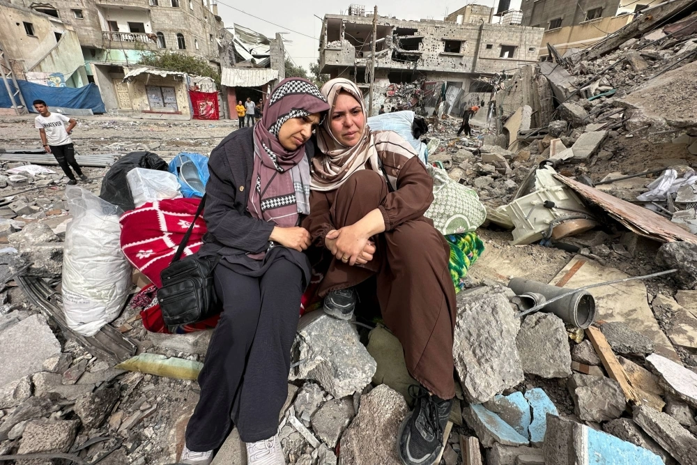 Palestinian women in Gaza sit amid the rubble of a residential building they once lived in, which was destroyed by an Israeli raid earlier this month. Palestinian women in Gaza sit amid the rubble of a residential building they once lived in, which was destroyed by an Israeli raid earlier this month.