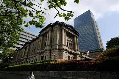 A woman walks past the Bank of Japan headquarters in central Tokyo on Friday. A woman walks past the Bank of Japan headquarters in central Tokyo on Friday.
