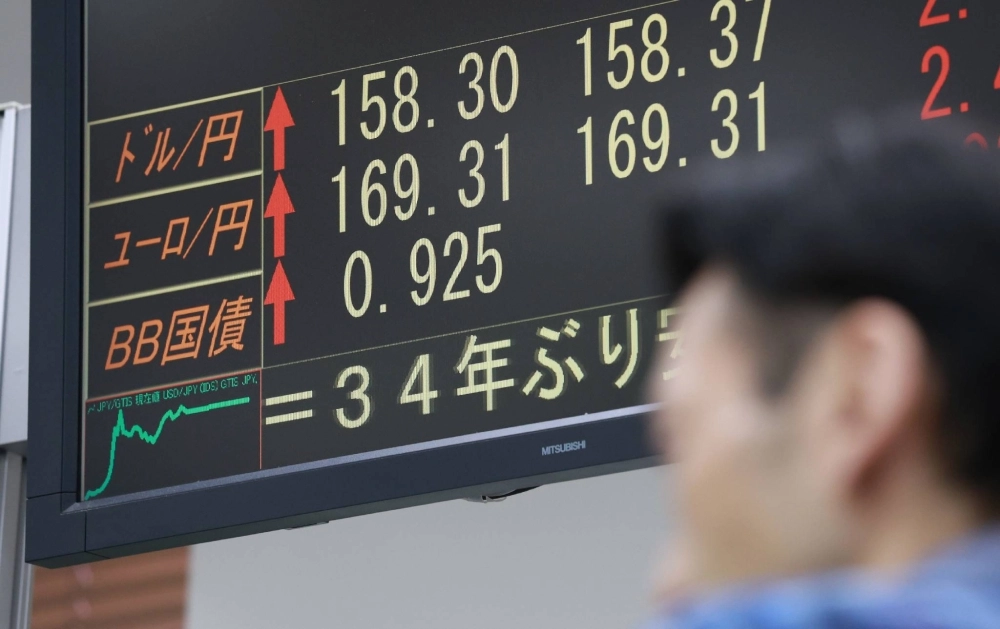 A monitor shows the yen's sharp decline to  ¥158 to the dollar on Saturday morning in Tokyo. A monitor shows the yen's sharp decline to  ¥158 to the dollar on Saturday morning in Tokyo.