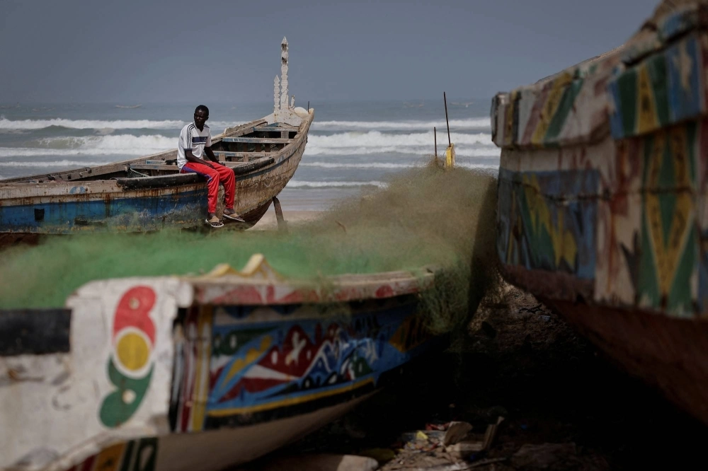 Birane Mbaye, one of the survivors of a disastrous attempt to reach Spain last year, sits on a wooden fishing boat at the shore of Fass Boye, Senegal. Birane Mbaye, one of the survivors of a disastrous attempt to reach Spain last year, sits on a wooden fishing boat at the shore of Fass Boye, Senegal.