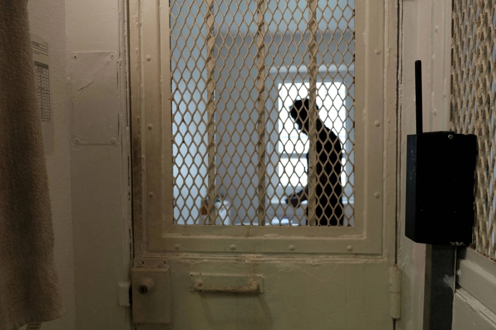 A prisoner stands behind the door of a cell in the isolation section of the Villepinte detention center in Villepinte, near Paris. A prisoner stands behind the door of a cell in the isolation section of the Villepinte detention center in Villepinte, near Paris.