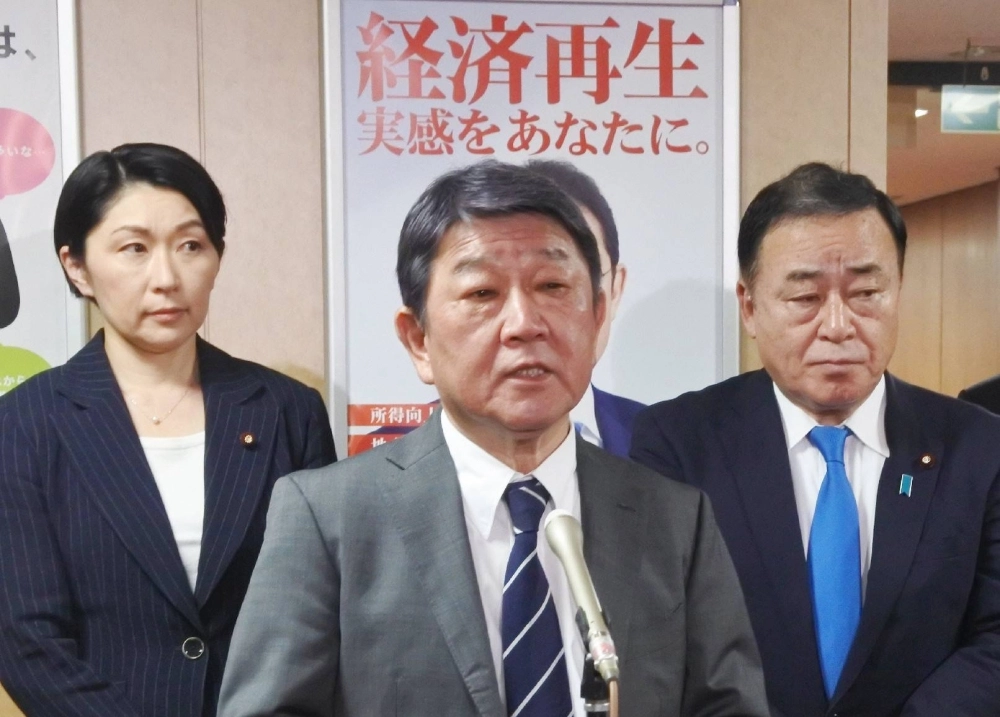 LDP Secretary-General Toshimitsu Motegi (center) speaks to reporters as election strategy committee chair Yuko Obuchi (left) and Deputy Secretary-General Hiroshi Kajiyama look on at party's headquarters in Tokyo on Sunday night. LDP Secretary-General Toshimitsu Motegi (center) speaks to reporters as election strategy committee chair Yuko Obuchi (left) and Deputy Secretary-General Hiroshi Kajiyama look on at party's headquarters in Tokyo on Sunday night.