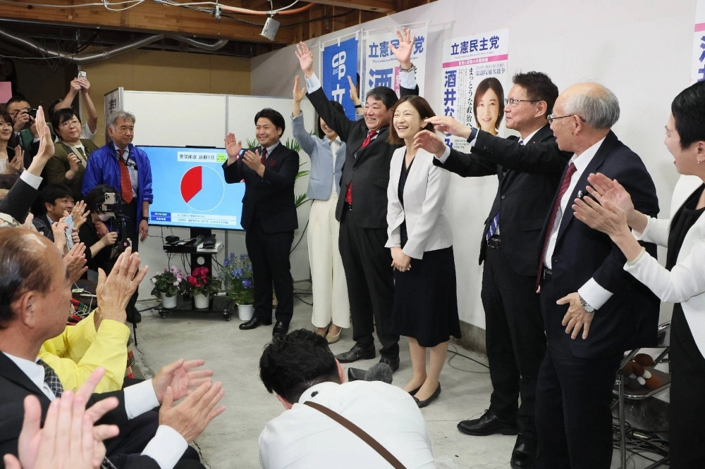 The Constitutional Democratic Party of Japan's Natsumi Sakai (center) celebrates with other CDP officials and supporters on Sunday in Tokyo's Koto Ward after being announced as the winner of the Tokyo No. 15 district by-election. The Constitutional Democratic Party of Japan's Natsumi Sakai (center) celebrates with other CDP officials and supporters on Sunday in Tokyo's Koto Ward after being announced as the winner of the Tokyo No. 15 district by-election.
