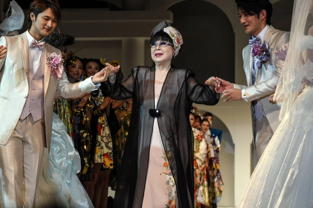 Japanese fashion designer Yumi Katsura (center) greets guests during the finale of the 2015 Yumi Katsura Grand Collection in Tokyo. Katsura has died at the age of 94. Japanese fashion designer Yumi Katsura (center) greets guests during the finale of the 2015 Yumi Katsura Grand Collection in Tokyo. Katsura has died at the age of 94.