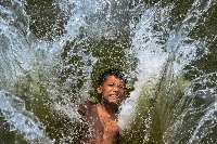 A child playfully takes a dip in a lake to get respite from the heat on a summer afternoon in Dhaka on Monday.. | AFP-JIJI