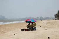 A vendor selling coconut water waits for customers at a beach on a hot day in Mumbai, India, on Monday.  | REUTERS
