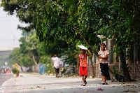 Children hold cork sheets to cover them from the sun while walking along a street during a countrywide heat wave in Dhaka, Bangladesh, on Sunday. | REUTERS