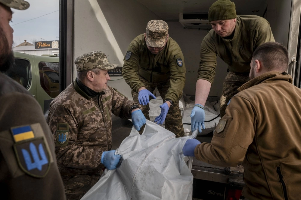 Morgue staff work with members of On The Shield, an organization tasked with collecting bodies of killed soldiers, at a morgue in the Donetsk region, Ukraine, on March 29. Ukraine struggles to name its dead; families of some soldiers say they have spent months trying to get official confirmation of their loved one’s death, adding to their anguish.  Morgue staff work with members of On The Shield, an organization tasked with collecting bodies of killed soldiers, at a morgue in the Donetsk region, Ukraine, on March 29. Ukraine struggles to name its dead; families of some soldiers say they have spent months trying to get official confirmation of their loved one’s death, adding to their anguish.