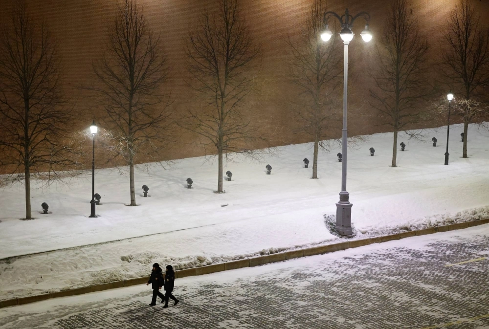 Law enforcement officers walk along the Kremlin wall near Red Square in Moscow on Dec. 31.  Law enforcement officers walk along the Kremlin wall near Red Square in Moscow on Dec. 31.