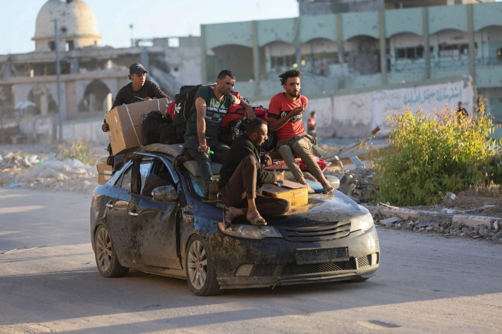 Displaced Palestinians who fled Rafah ride atop a car in Khan Younis in the southern Gaza Strip on Monday.  Displaced Palestinians who fled Rafah ride atop a car in Khan Younis in the southern Gaza Strip on Monday.