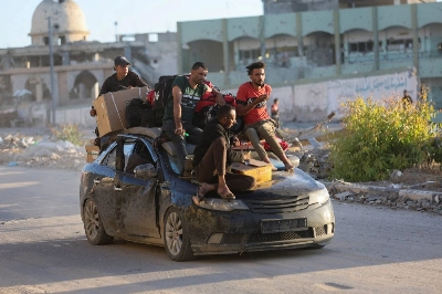 Displaced Palestinians who fled Rafah ride atop a car in Khan Younis in the southern Gaza Strip on Monday.  Displaced Palestinians who fled Rafah ride atop a car in Khan Younis in the southern Gaza Strip on Monday.