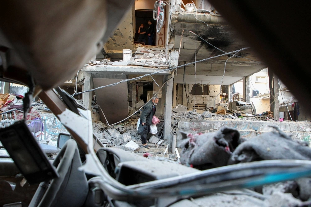 A Palestinian man leaves a house hit by an Israeli strike in Rafah, in the southern Gaza Strip, on Thursday. A Palestinian man leaves a house hit by an Israeli strike in Rafah, in the southern Gaza Strip, on Thursday.