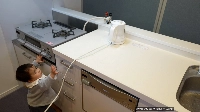 A toddler tries to pull an electric kettle cord. Parents can often recognize the dangers within their own home, but may not be as vigilant when visiting new places during the holidays. | National Institute of Technology and Evaluation / VIA JIJI