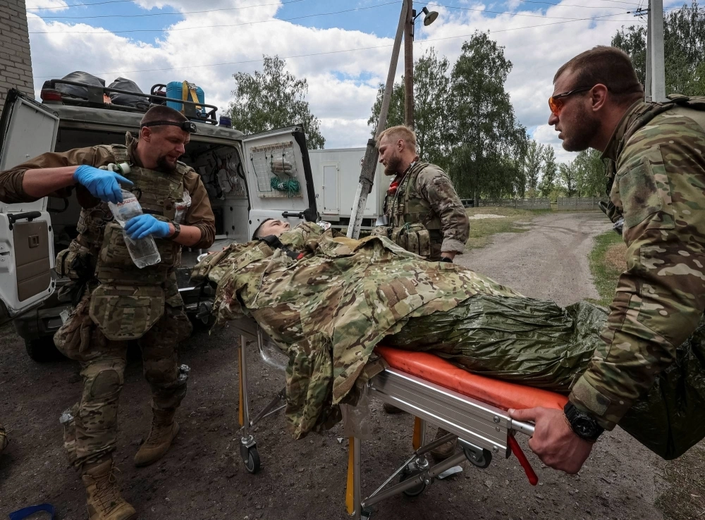 Military paramedics treat a wounded Ukrainian service member, amid Russia's attack on Ukraine, near the town of Vovchansk in Kharkiv region of Ukraine on Sunday.   Military paramedics treat a wounded Ukrainian service member, amid Russia's attack on Ukraine, near the town of Vovchansk in Kharkiv region of Ukraine on Sunday.