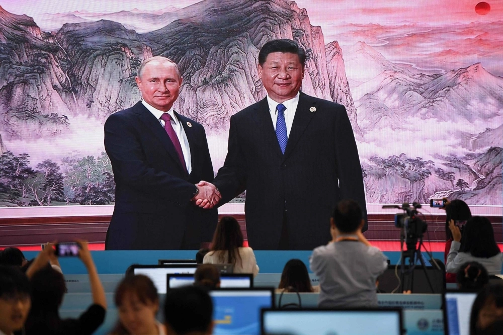 A screen shows Chinese leader Xi Jinping shaking hands with Russian President Vladimir Putin before a meeting with the leaders of Shanghai Cooperation Organization members at the SCO Summit in Qingdao, China, in June 2018. A screen shows Chinese leader Xi Jinping shaking hands with Russian President Vladimir Putin before a meeting with the leaders of Shanghai Cooperation Organization members at the SCO Summit in Qingdao, China, in June 2018.