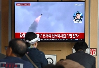 A news broadcast on a screen at a Seoul railway station shows file footage of a past North Korean missile test. | AFP-Jiji