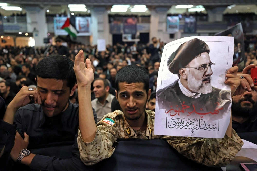 Mourners holds posters of late Iranian President Ebrahim Raisi during a funeral ceremony for him and his companions who were killed in a helicopter crash, at Mosalia mosque in Tehran on Tuesday. Mourners holds posters of late Iranian President Ebrahim Raisi during a funeral ceremony for him and his companions who were killed in a helicopter crash, at Mosalia mosque in Tehran on Tuesday.