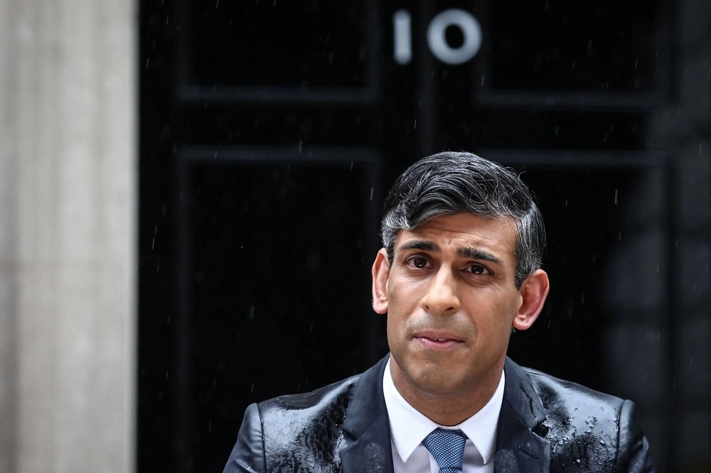 British Prime Minister Rishi Sunak, soaked in rain,  pauses as he delivers a speech to announce July 4 as the date of the U.K.'s next general election, at 10 Downing Street in London on Wednesday. British Prime Minister Rishi Sunak, soaked in rain,  pauses as he delivers a speech to announce July 4 as the date of the U.K.'s next general election, at 10 Downing Street in London on Wednesday.
