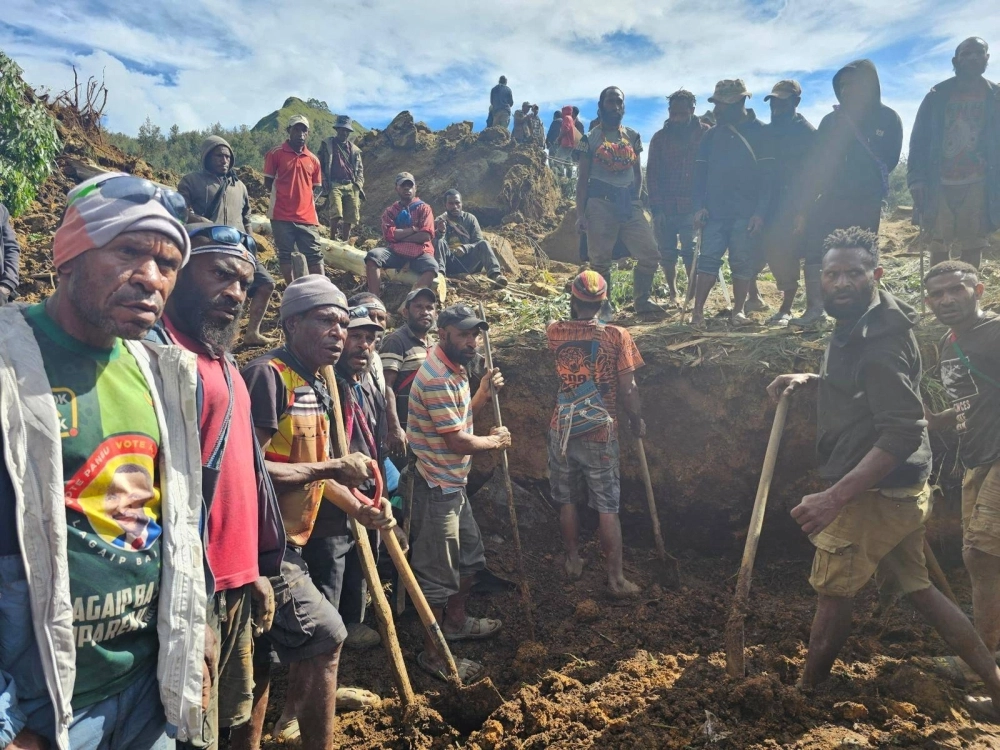 Locals gather amid the damage after a landslide in Maip Mulitaka, Enga province, Papua New Guinea, on Friday. Locals gather amid the damage after a landslide in Maip Mulitaka, Enga province, Papua New Guinea, on Friday.