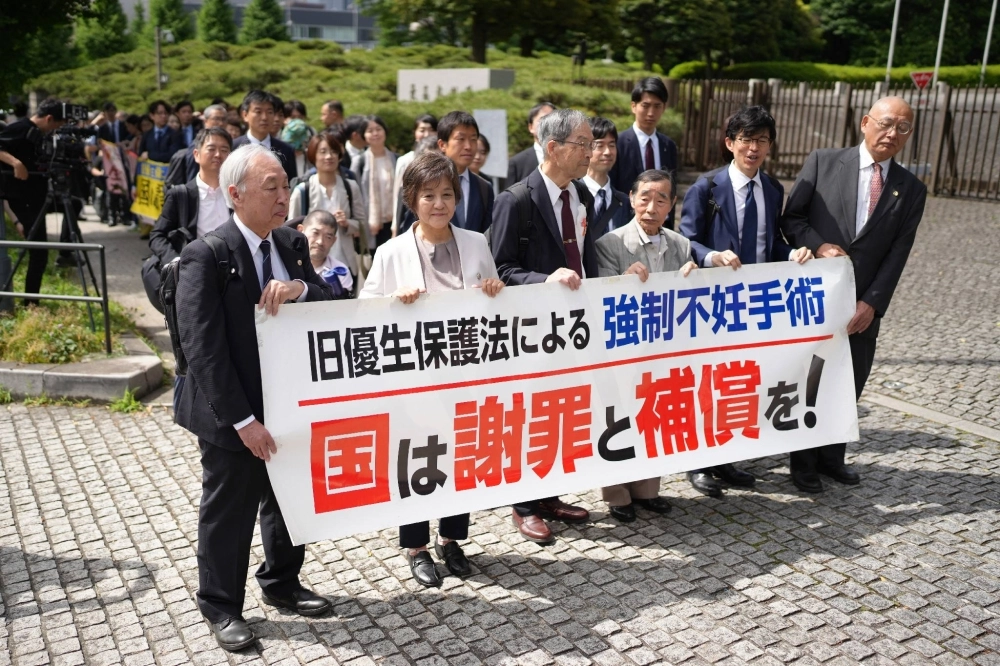 Plaintiffs and lawyers march to the Supreme Court to attend a hearing on lawsuits against the government over forced sterilization carried out under a now-defunct eugenic law, on Wednesday in Tokyo's Chiyoda Ward. Plaintiffs and lawyers march to the Supreme Court to attend a hearing on lawsuits against the government over forced sterilization carried out under a now-defunct eugenic law, on Wednesday in Tokyo's Chiyoda Ward.