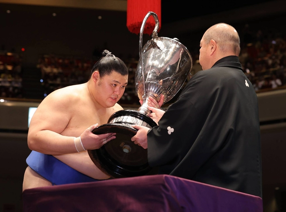 Onosato receives the Emperor's Cup from Japan Sumo Association Chairman Hakkaku at Ryogoku Kokugikan in Tokyo on Sunday. Onosato receives the Emperor's Cup from Japan Sumo Association Chairman Hakkaku at Ryogoku Kokugikan in Tokyo on Sunday.