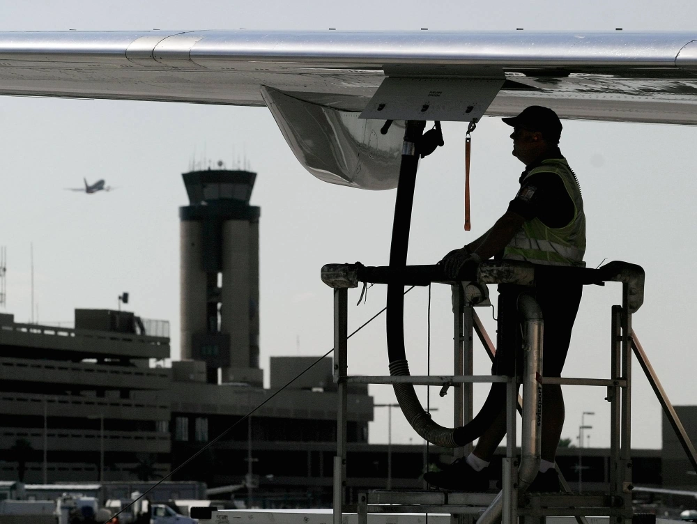 A ground crew worker refuels a plane at Phoenix Sky Harbor International Airport in Arizona.  A ground crew worker refuels a plane at Phoenix Sky Harbor International Airport in Arizona.