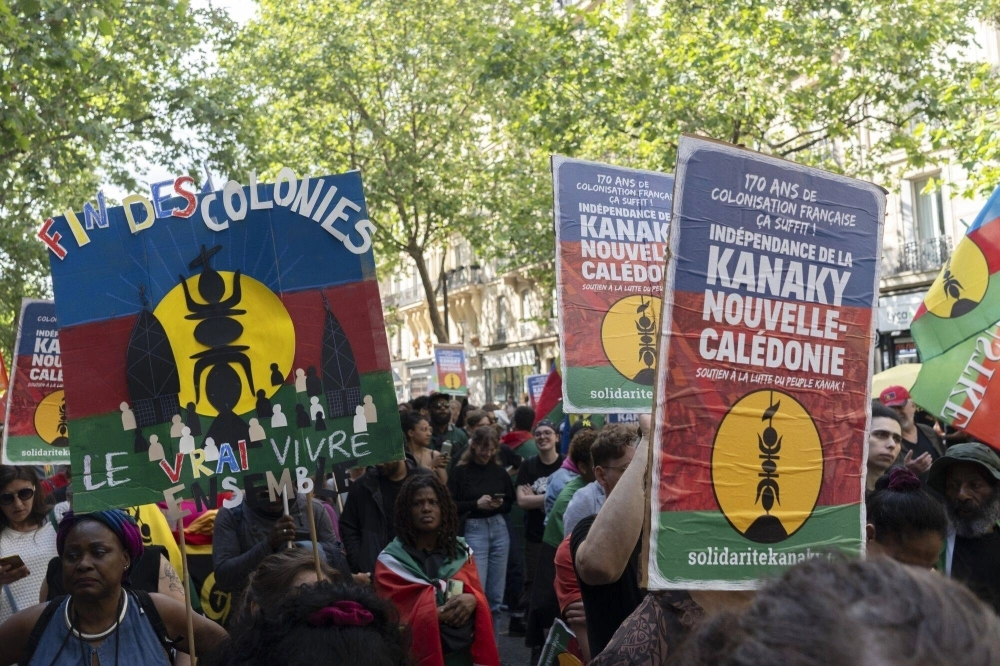 Protesters march at a solidarity rally in support of New Caledonia's Kanak people in Paris on May 25. The Pacific territory of 270,000 people has been in turmoil since May 13, when violence erupted over plans to extend voting rights to more residents, which Indigenous Kanaks say would diminish their electoral influence. Protesters march at a solidarity rally in support of New Caledonia's Kanak people in Paris on May 25. The Pacific territory of 270,000 people has been in turmoil since May 13, when violence erupted over plans to extend voting rights to more residents, which Indigenous Kanaks say would diminish their electoral influence.