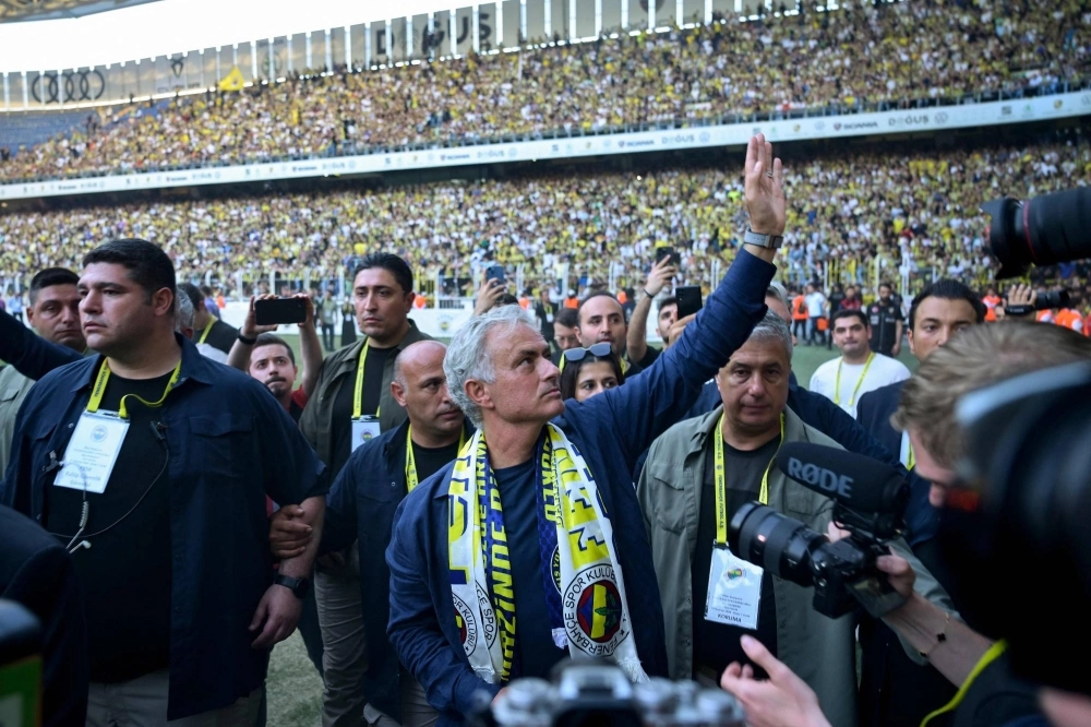 New coach of Turkish club Fenerbahce Jose Mourinho (center) waves to supporters at the Sukru Saracoglu Stadium in Istanbul on Sunday. New coach of Turkish club Fenerbahce Jose Mourinho (center) waves to supporters at the Sukru Saracoglu Stadium in Istanbul on Sunday.