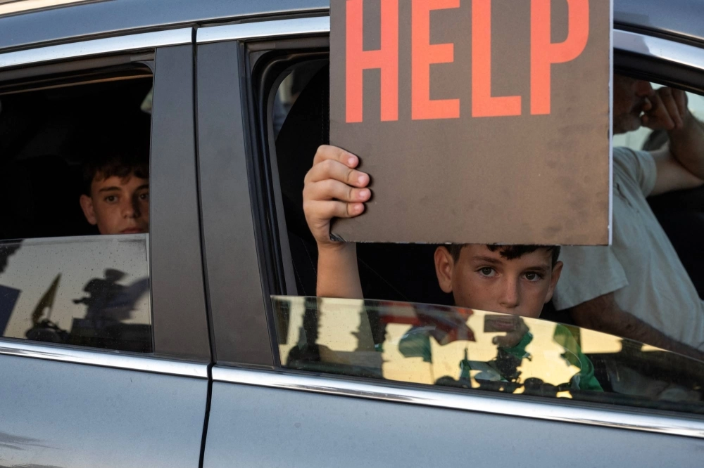 A child holds a sign during a rally demanding the release of Israeli hostages outside the U.S. consulate in Tel Aviv on Monday. A child holds a sign during a rally demanding the release of Israeli hostages outside the U.S. consulate in Tel Aviv on Monday.