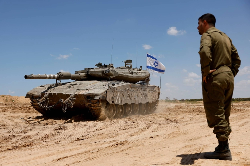 An Israeli soldier stands next to a tank near the Israel-Gaza Border on May 7. An Israeli soldier stands next to a tank near the Israel-Gaza Border on May 7.