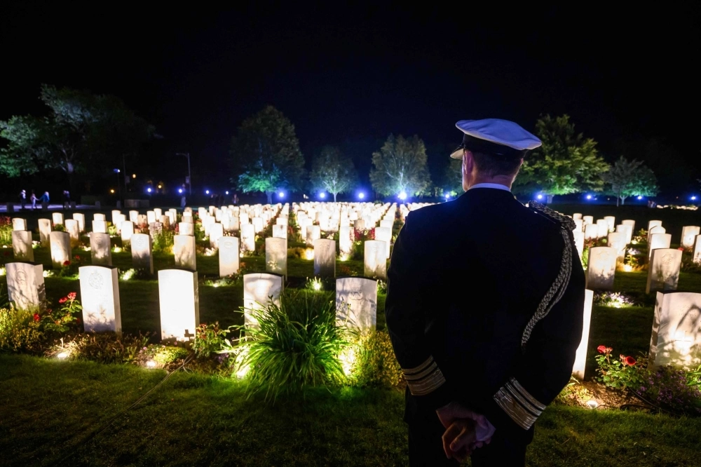 A British officer looks at illuminated graves at the Bayeux War Cemetery in northwestern France on Wednesday ahead of D-Day commemorations marking the 80th anniversary of the Allies' landings in Normandy on June 6, 1944, during World War II.  A British officer looks at illuminated graves at the Bayeux War Cemetery in northwestern France on Wednesday ahead of D-Day commemorations marking the 80th anniversary of the Allies' landings in Normandy on June 6, 1944, during World War II.