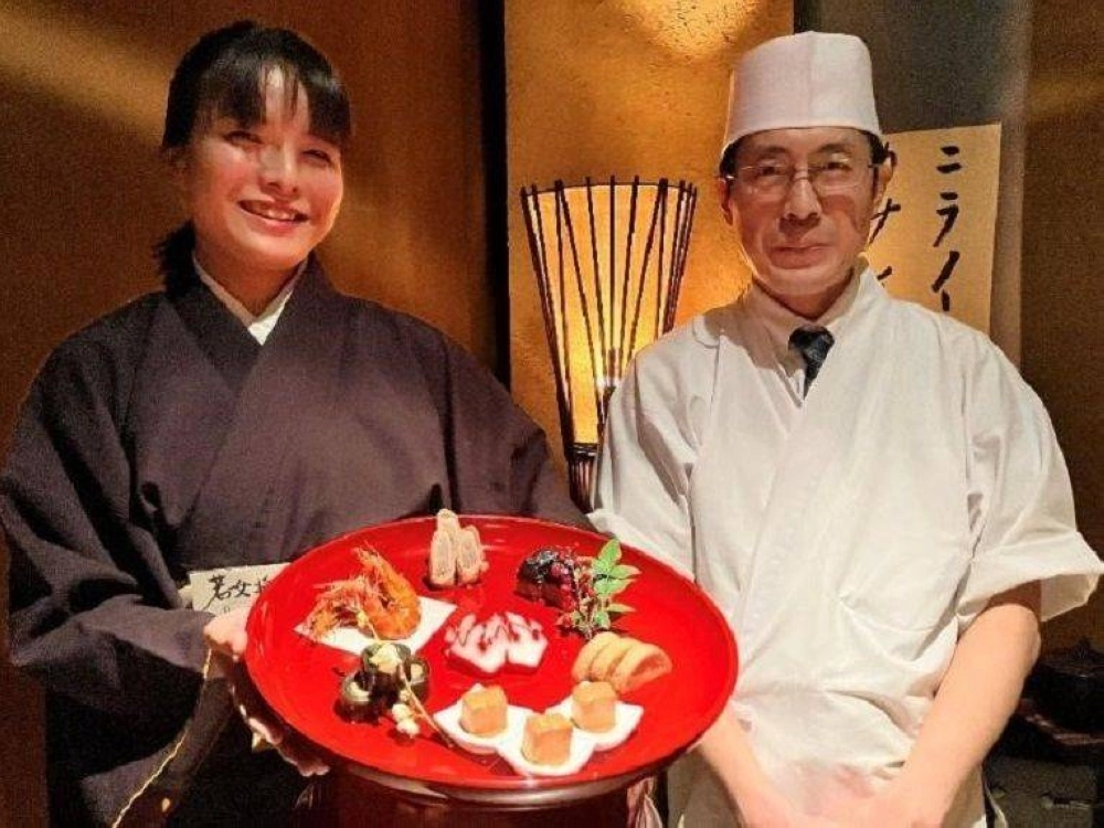Kenji Iikura (right), head chef at Akasaka Tantei, and manager Hibiki Kitazawa pose with Okinawan cuisine served at the restaurant in Tokyo. Kenji Iikura (right), head chef at Akasaka Tantei, and manager Hibiki Kitazawa pose with Okinawan cuisine served at the restaurant in Tokyo.