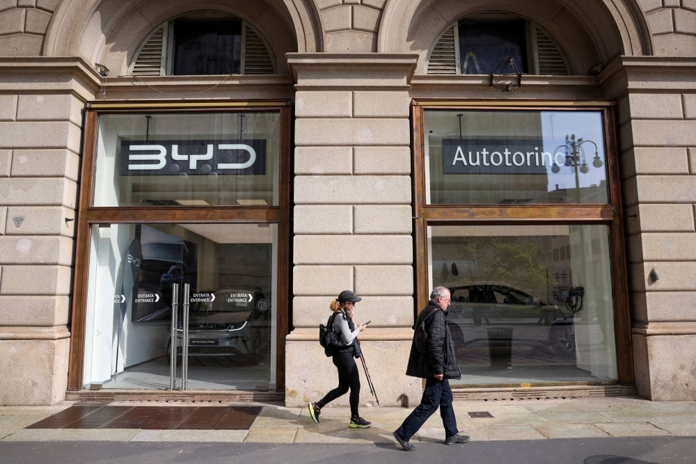 People walk in front of a BYD Auto company and Autotorino store in Milan on March 20. People walk in front of a BYD Auto company and Autotorino store in Milan on March 20.