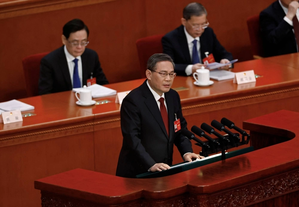 Chinese Premier Li Qiang delivers the work report at the opening session of the National People's Congress in Beijing on March 5. Li dropped the mention of "peaceful" from unification with Taiwan this year. Chinese Premier Li Qiang delivers the work report at the opening session of the National People's Congress in Beijing on March 5. Li dropped the mention of "peaceful" from unification with Taiwan this year.