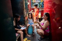 A mother records a video of her daughter reading a school assignment following the suspension of in-person classes, outside their house, in Manila on April 26. | REUTERS
