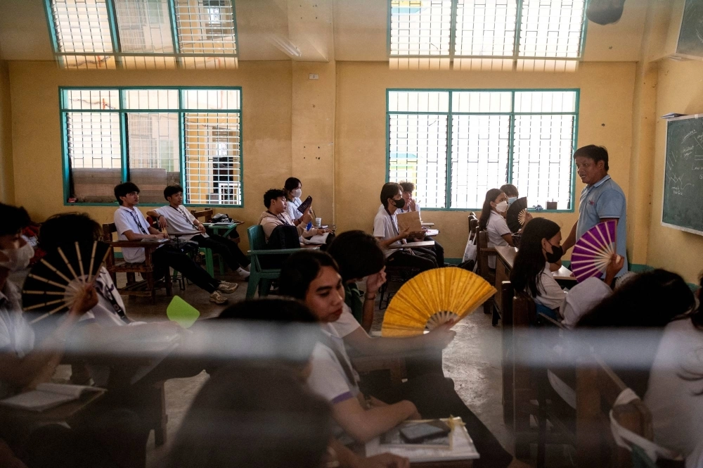 Grade 12 students use hand fans as they attend a class at the Commonwealth High School, in Quezon City, Metro Manila, Philippines, on April 18. Grade 12 students use hand fans as they attend a class at the Commonwealth High School, in Quezon City, Metro Manila, Philippines, on April 18.