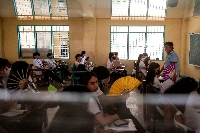 Grade 12 students use hand fans as they attend a class at the Commonwealth High School, in Quezon City, Metro Manila, Philippines, on April 18. | REUTERS