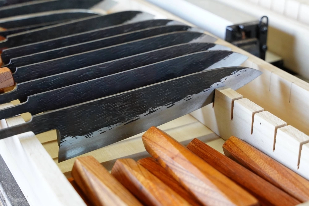 Isamitsu Knives makes their blades in large batches to optimize the use of both the resources at its disposal and its small team of three smiths. Isamitsu Knives makes their blades in large batches to optimize the use of both the resources at its disposal and its small team of three smiths.