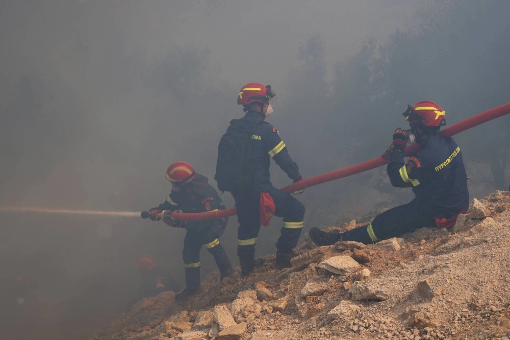 Firefighters try to tackle a wildfire burning near the village of Resta on the island of Chios, Greece, on June 7. Firefighters try to tackle a wildfire burning near the village of Resta on the island of Chios, Greece, on June 7.