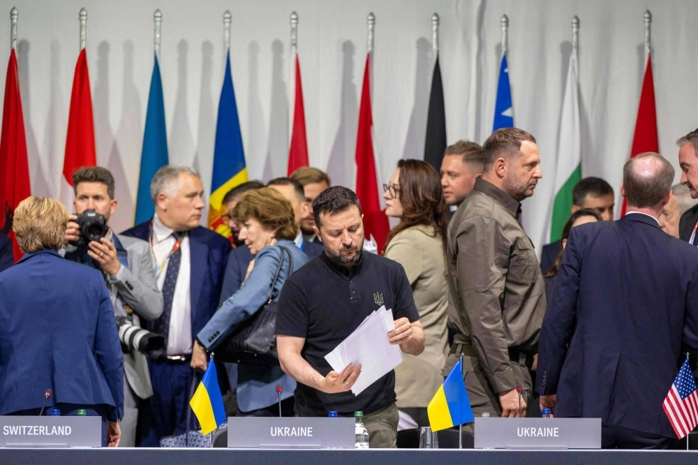 Ukrainian President Volodymyr Zelenskyy looks at papers as he attends a plenary session during a peace summit at the luxury Burgenstock resort in Switzerland on Sunday. Ukrainian President Volodymyr Zelenskyy looks at papers as he attends a plenary session during a peace summit at the luxury Burgenstock resort in Switzerland on Sunday.