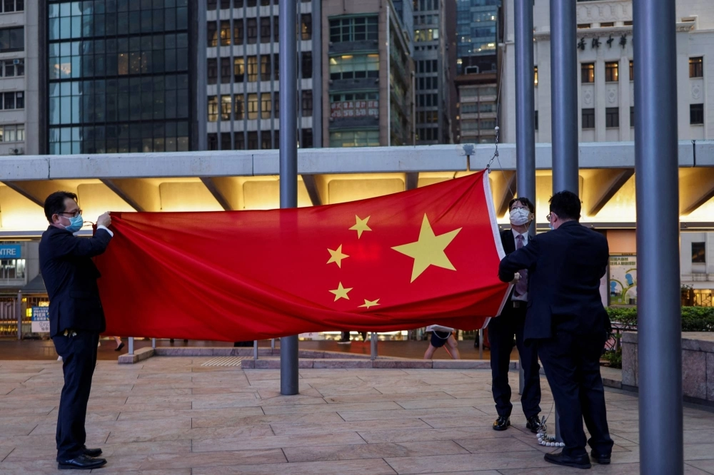 Staff lower the Chinese national flag in the Central Financial District in Hong Kong in March. Hong Kong is an established trading hub for raising capital while Singapore excels in private wealth management. Staff lower the Chinese national flag in the Central Financial District in Hong Kong in March. Hong Kong is an established trading hub for raising capital while Singapore excels in private wealth management.