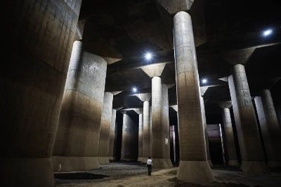 A person walks among the giant columns supporting the Metropolitan Area Outer Underground Discharge Channel in Saitama Prefecture. A person walks among the giant columns supporting the Metropolitan Area Outer Underground Discharge Channel in Saitama Prefecture.