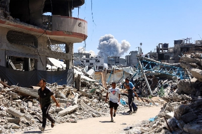 People run for cover during an Israeli bombardment in Gaza City on Saturday. People run for cover during an Israeli bombardment in Gaza City on Saturday.