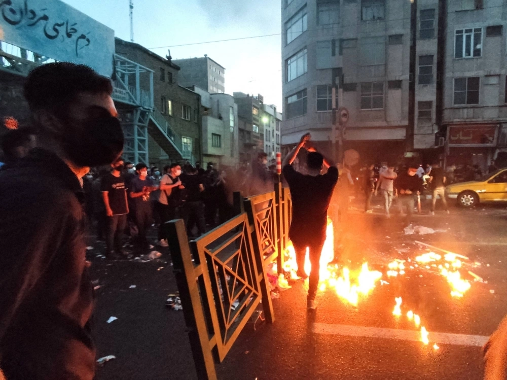 People light a fire during a protest over the death of Mahsa Amini, a woman who died after being arrested by the Islamic republic's "morality police," in Tehran on Sept. 21, 2022.  People light a fire during a protest over the death of Mahsa Amini, a woman who died after being arrested by the Islamic republic's "morality police," in Tehran on Sept. 21, 2022.