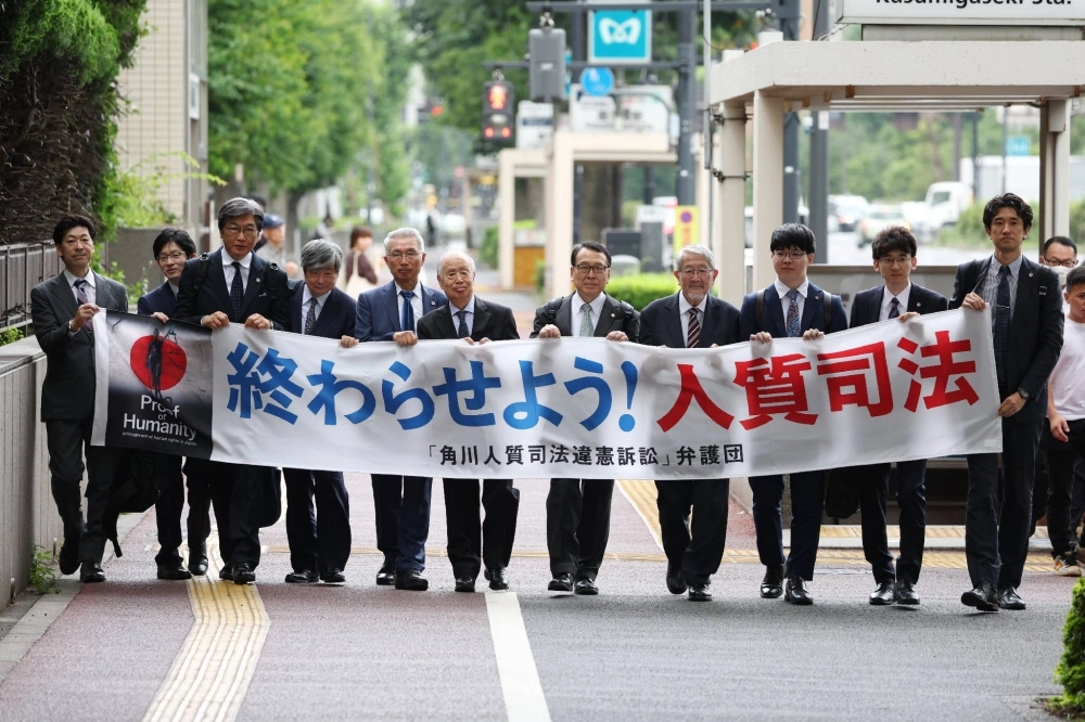 Tsuguhiko Kadokawa (center) and his lawyers head to the Tokyo District Court on Thursday to file the lawsuit against the state. Tsuguhiko Kadokawa (center) and his lawyers head to the Tokyo District Court on Thursday to file the lawsuit against the state.